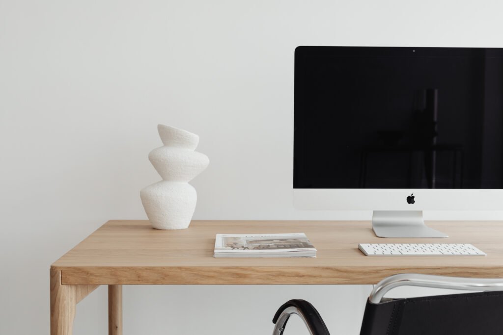 Ambiance de travail pour la création de site web avec iMac, clavier sur un bureau en bois clair ambiance moderne et élégante